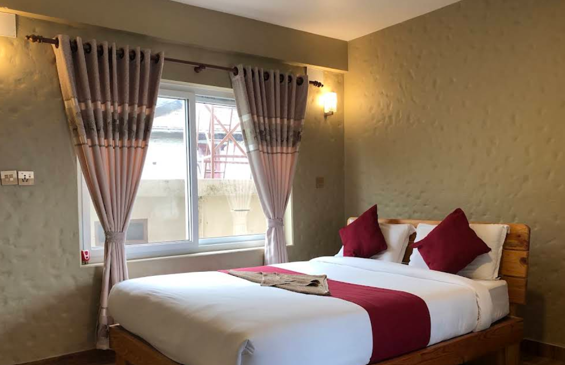 A double room in soft neutrals with deep burgundy accents